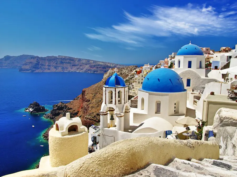 Igrejas de cúpula azul em Oia, Santorini, de frente para o mar
